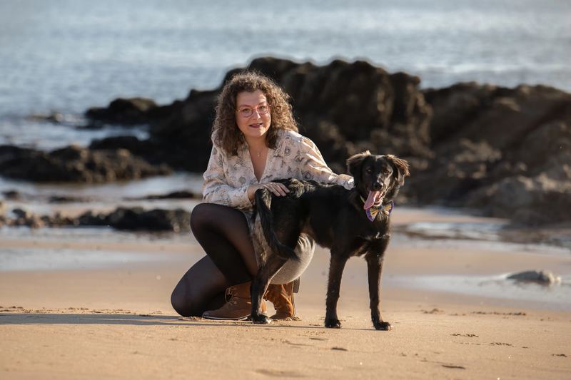 Femme et son chien noir sur la plage
