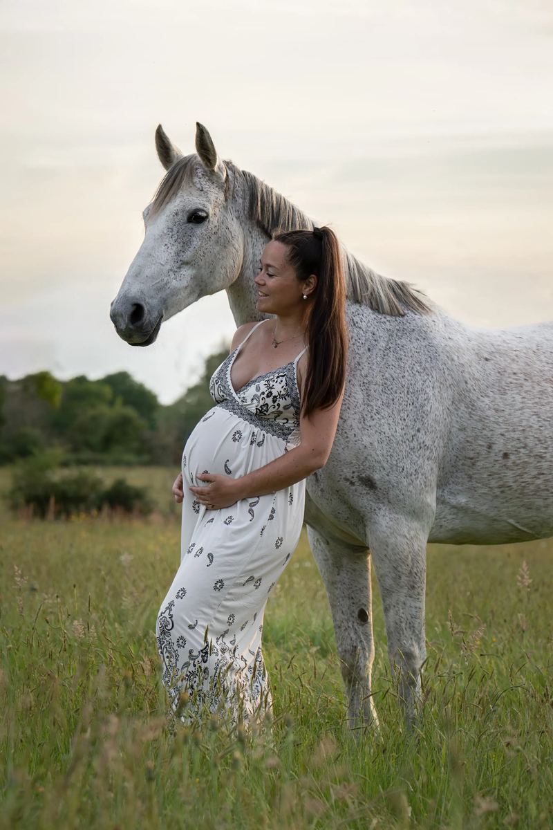 Femme enceinte avec un cheval blanc